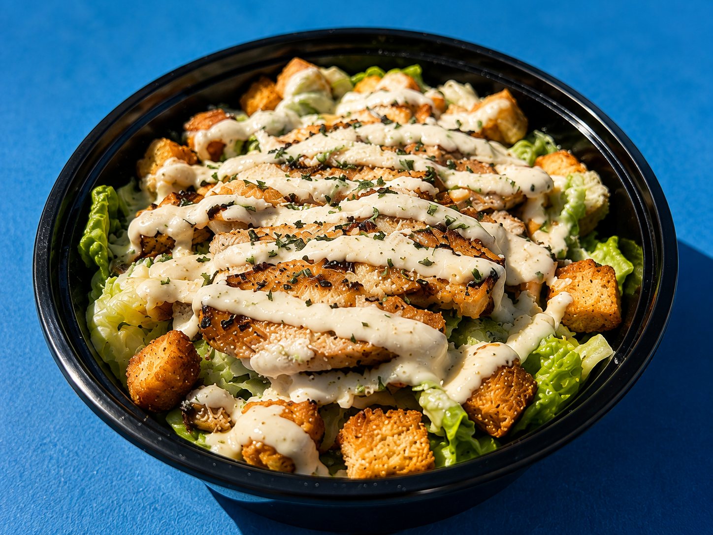 A chicken Caesar salad with grilled chicken, parmesan and croutons