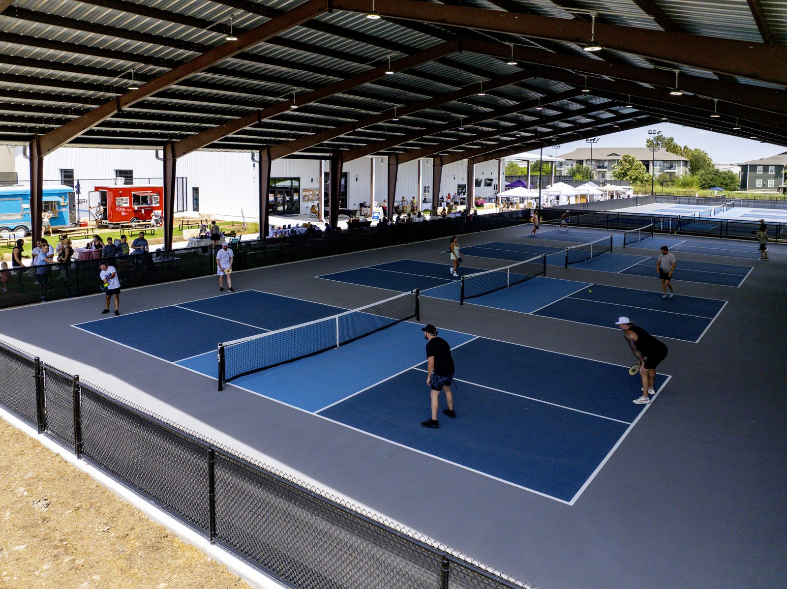 The covered pickleball courts at RacFit on an event day, with the Yachties truck parked at the edge of the lawn
