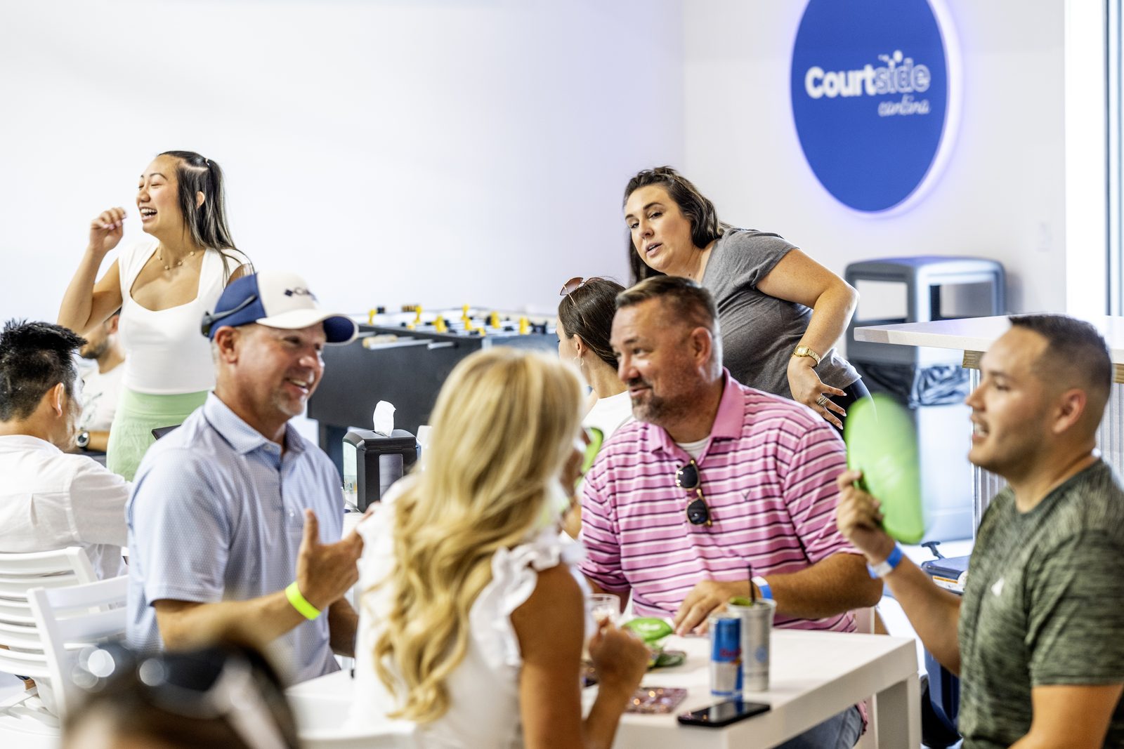 Guests laughing around a table inside the Courtside Cantina